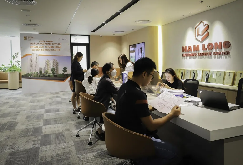 Nhân viên Nam Long hỗ trợ khách hàng hoàn tất hồ sơ nhận sổ hồng Akari City